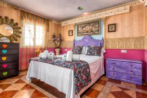 a bedroom with a purple bed and a purple dresser at La Casa Del Maestro in Estepona