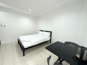 una habitación blanca con una cama y una mesa en Patong Canal Villa 106, en Patong Beach