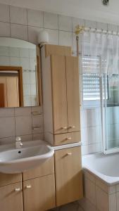 a white bathroom with a sink and a mirror at Ferienwohnung Schiffner in Hengnau