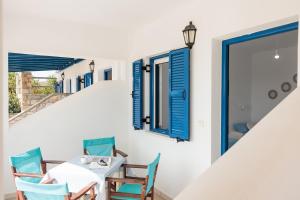 a dining room with blue windows and a table and chairs at Aurea Blu Studio 04, enjoy peace, quiet, sand and sea in Aliko Beach