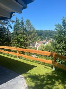 a wooden fence in a yard with a view at Ferienwohnung Vita-Natura in Eppenbrunn