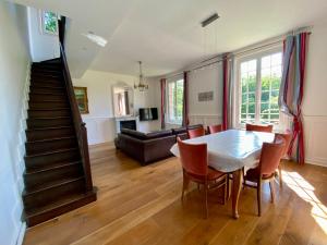 a living room with a table and chairs and a couch at Magnifique Maison vue mer 150m de la plage in Trouville-sur-Mer