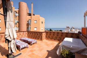 a balcony with two chairs and umbrellas on a building at La Casa Del Maestro in Estepona
