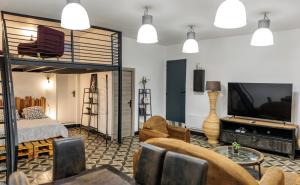un salon avec une mezzanine et une télévision dans l'établissement Loft SSL insolite!!!, à Gignac-la-Nerthe