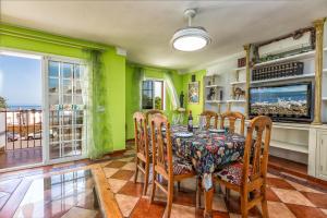 a dining room with green walls and a table and chairs at La Casa Del Maestro in Estepona
