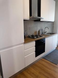 a kitchen with white cabinets and a stove top oven at Marghera Piazza Mercato A - Easy to Venice e FREE park in Venice