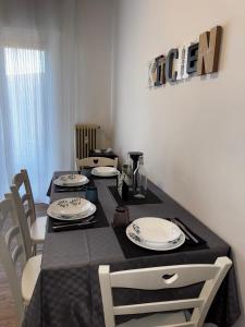 a dining room table with a black table cloth and white plates at Marghera Piazza Mercato A - Easy to Venice e FREE park in Venice +8 photos