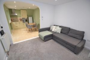 a living room with a couch and a kitchen at Sweet Bea Bungalow - 4 Bed - Garden - Huge Drive - Maidstone in Maidstone