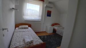 Una pequeña habitación con dos camas y una ventana. en Family home EHLI, en Vogošća