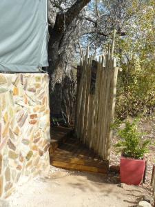 un portico di legno con una recinzione accanto a un albero di Tjhora Sunset Cottage a Cambridge Altre 50 foto