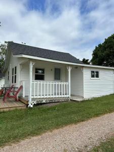 una casa blanca con un porche y un patio en Sea breeze Retreat-3-bedroom watterfront cottage, en Stanhope