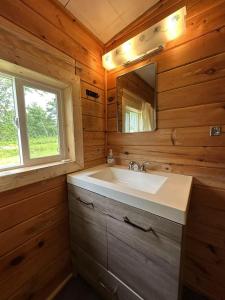 un baño con lavabo y espejo en Sea breeze Retreat-3-bedroom watterfront cottage, en Stanhope