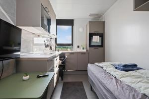 a small bedroom with a bed and a kitchen at EcoStay Comfort in compact format nr two in Horten