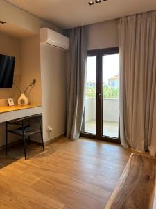 a living room with a desk and a sliding glass door at ΝΕΑΚΙΤΟΣ Luxury Apartments in Nikiti