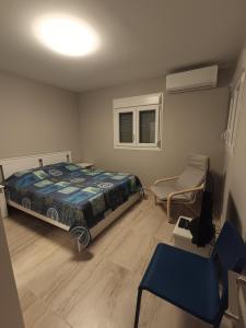 a bedroom with a bed and a chair in it at SunRay Halkidiki Home & Garden in Kalyves Poligirou