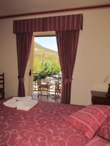 een slaapkamer met een bed en uitzicht op een tafel bij Porto Fico Hotel in Vasiliki