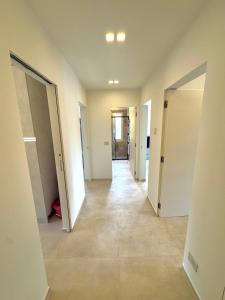 an empty hallway with white walls and floors and doors at Family apartment in Rapallo