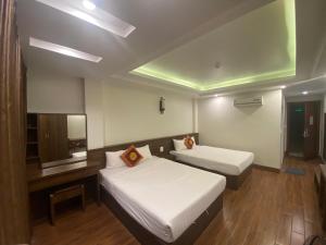 a hotel room with two beds and a tv at MAI VANG Hotel in Sapa