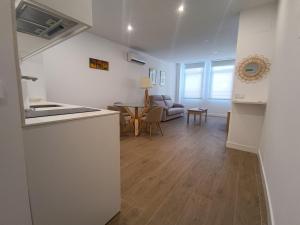 una cucina e un soggiorno con un divano e un tavolo di Apartamentos BONDELA a Madrid Altre 3 foto