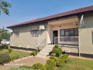 a house with a staircase in front of it at Luta Serviced Apartment in Lusaka