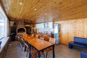 a dining room with a long wooden table and chairs at Buturuga Mică in Nehoiu