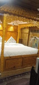 een groot houten bed in een kamer bij Jacqueline houseboat in Srinagar