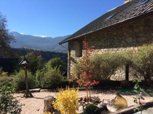 a garden in front of a building with mountains in the background at Chambre d'hôtes La Font in Eygliers
