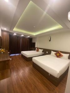 a hotel room with two beds and a table at MAI VANG Hotel in Sapa