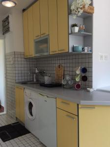 a kitchen with yellow cabinets and a washing machine at Budva Old City Central Studio Private in Budva