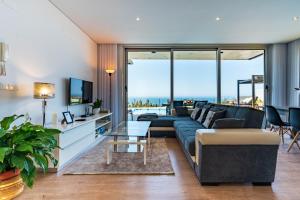 una sala de estar con un sofá y una mesa en Villa Pinheira III heated pool, en Calheta