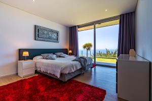 Un dormitorio con una cama y una ventana grande. en Villa Pinheira III heated pool, en Calheta 54 fotos más