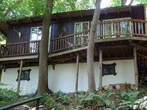 a tree house in the woods with a deck at Ferienhaus Gädda in Vöhl