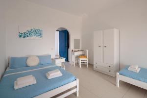 a white bedroom with a blue bed and a white cabinet at Aurea Blu Studio 07, warmth, sun, nature and sea in Aliko Beach