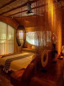 una camera con letto e lampadario a braccio di Ulaman Eco Luxury Resort a Tabanan Altre 37 foto