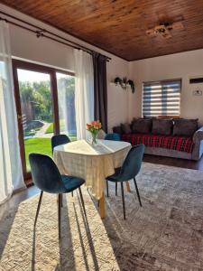 a living room with a table and chairs and a couch at Casuta Sofiei in Vîrfu Dealului