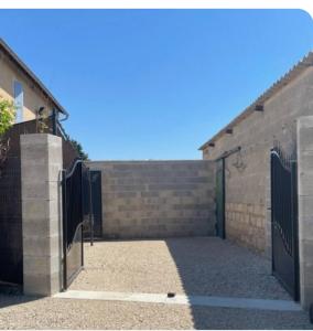 un cancello per una casa con un muro di mattoni di Nature&détente au pied du Mont Ventoux parking privé gratuit a Carpentras