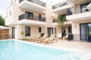 an apartment with a swimming pool in front of a building at Palm Suites in Nea Vrasna