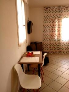 una stanza con un tavolo, due sedie e una finestra di Casa Dea a Rimini