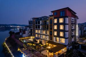 XintanHuangshan Tunxi Shangjiexing Riverview Resort Hotel的夜晚的建筑物与河流的景色