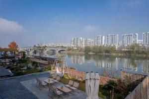 XintanHuangshan Tunxi Shangjiexing Riverview Resort Hotel的享有河流、桥梁和建筑的景色