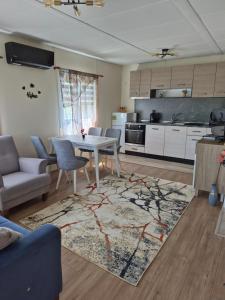 a living room with a table and a kitchen at Къщички Sunrise in Tsarevo