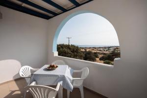 a dining room with an arch window and a table and chairs at Aurea Blu Studio 08, Enjoy, Relax, Dream in Aliko Beach