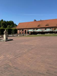 a large brick courtyard with a building in the background at Herberge in der Orangerie auf dem Schlossgut Altlandsberg in Altlandsberg