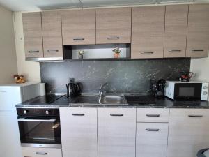 a kitchen with a sink and a microwave at Къщички Sunrise in Tsarevo +15 photos