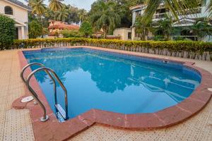 a large swimming pool with blue water at Corundum Twins in Arpora, 5 mins to Baga Calangute in Arpora