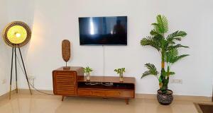 a living room with a tv on a wall with two plants at Corundum Twins in Arpora, 5 mins to Baga Calangute in Arpora