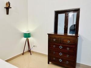 a dresser with a mirror and a lamp in a room at Corundum Twins in Arpora, 5 mins to Baga Calangute in Arpora