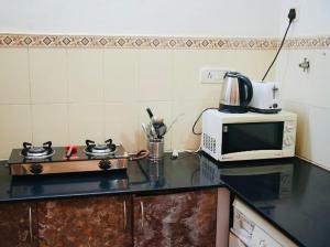 a kitchen with a microwave and a counter top at Corundum Twins in Arpora, 5 mins to Baga Calangute in Arpora