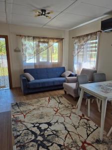 a living room with a blue couch and a table at Къщички Sunrise in Tsarevo