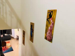 four paintings hanging on a wall in a living room at Corundum Twins in Arpora, 5 mins to Baga Calangute in Arpora